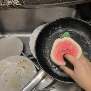 Customer cleaning frying pan with fruit scrubber