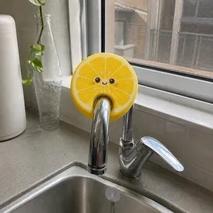 Fruit shaped scrubber clipped onto faucet