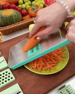 Handheld vegetable slicer being used with a carrot