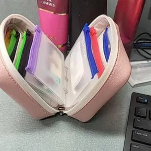 Pink organizer case with removable pouches on an office desk
