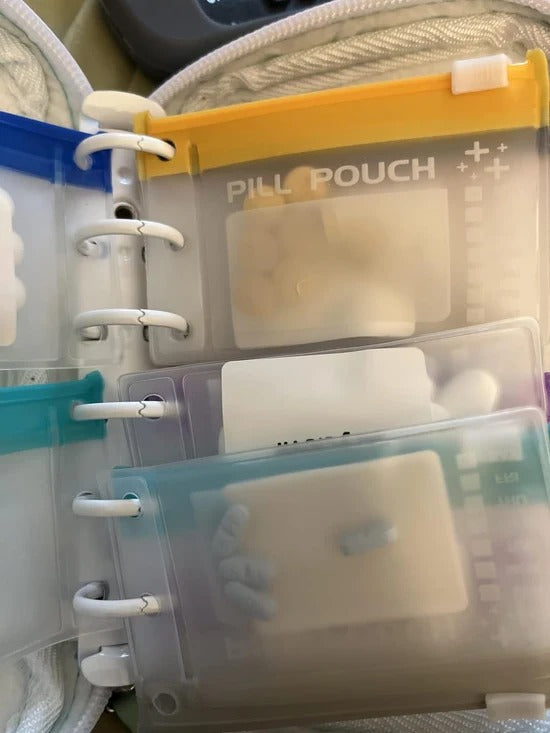 Close-up of removable pouches attached to the binder rings inside the organizer