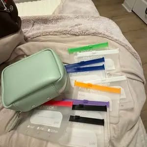Mint organizer case with removable labeled pouches laid out beside it