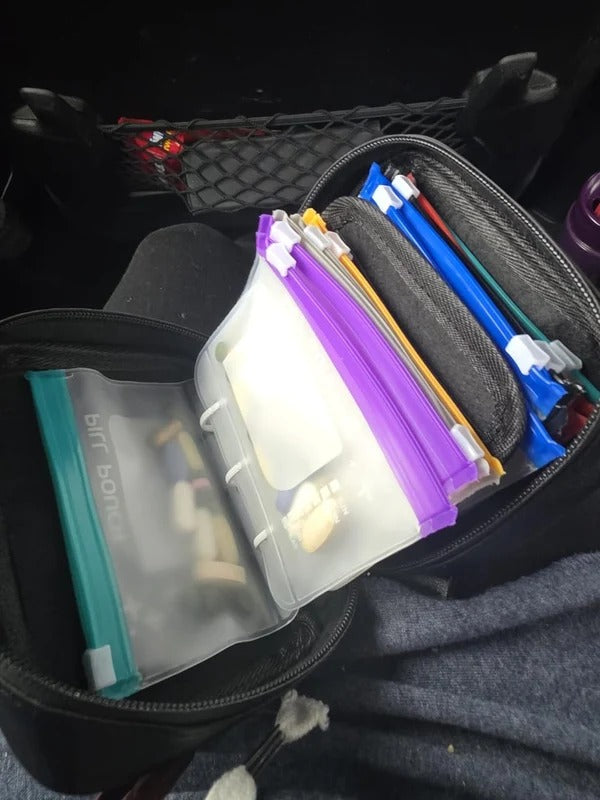 Black travel organizer with removable pill pouches in a car